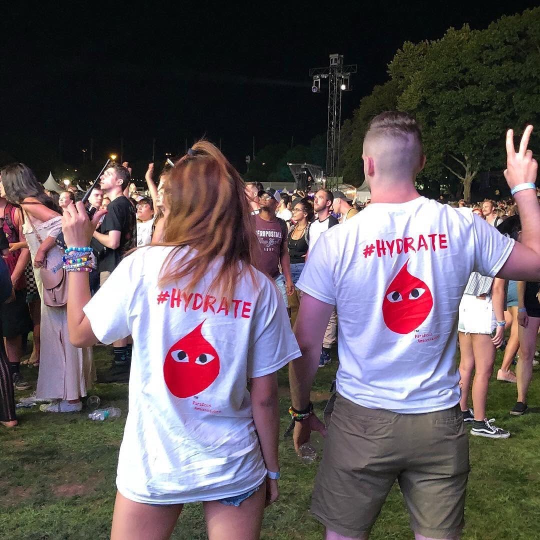 Ambassadors facing the crowd at a nighttime event, wearing #HYDRATE shirts